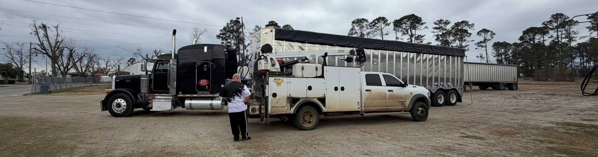 Picture of a Semi broken down and the diesel mechanic is on site diagnosing the problem